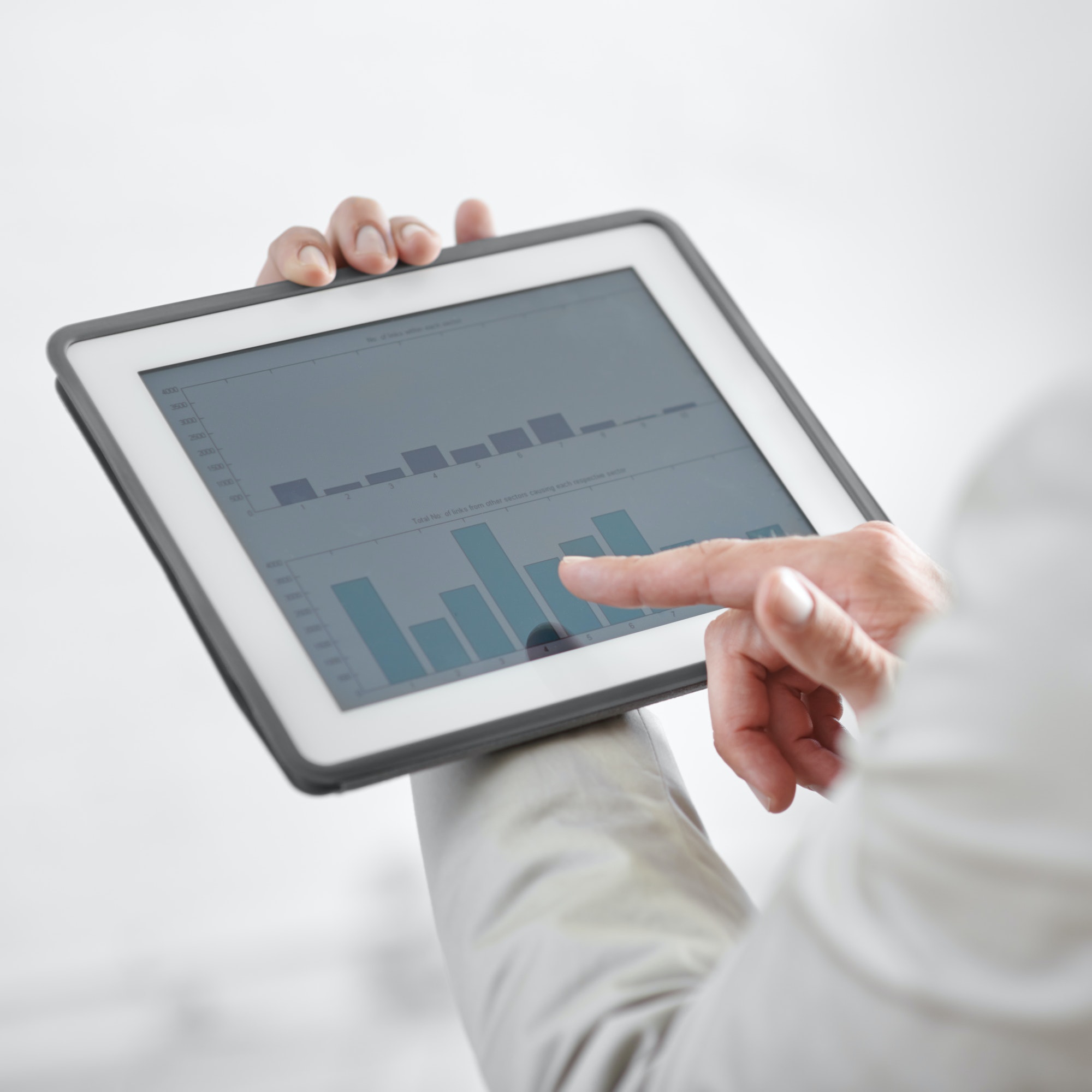 Cropped image of a businessman holding a digital tablet showing business data