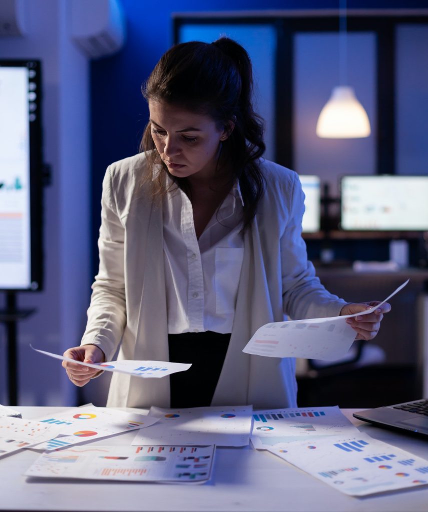 Stressed manager woman working with financial documents checking graphs